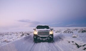 black GMC Sierra Denali on snow covered road