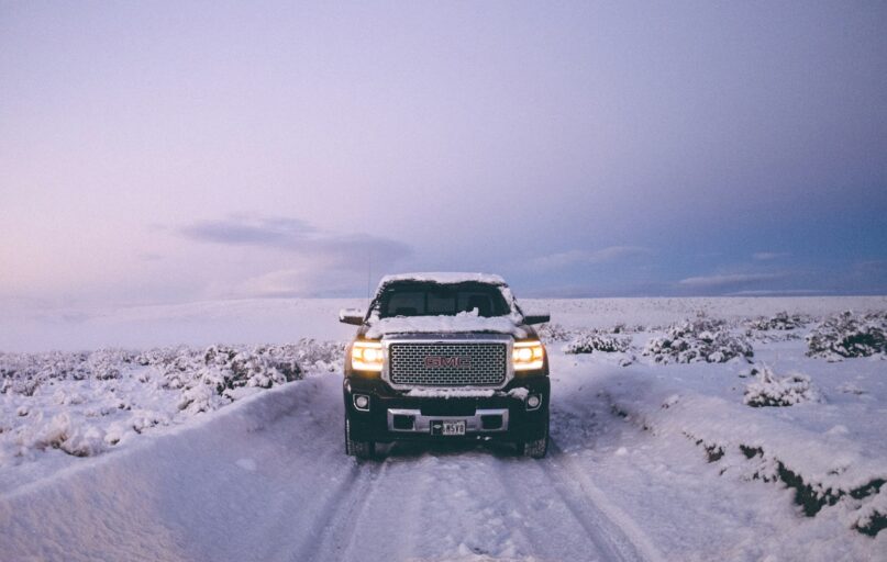 black GMC Sierra Denali on snow covered road