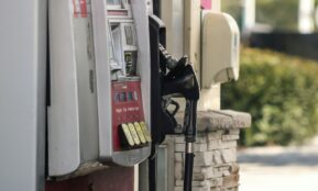 a gas pump next to a brick wall