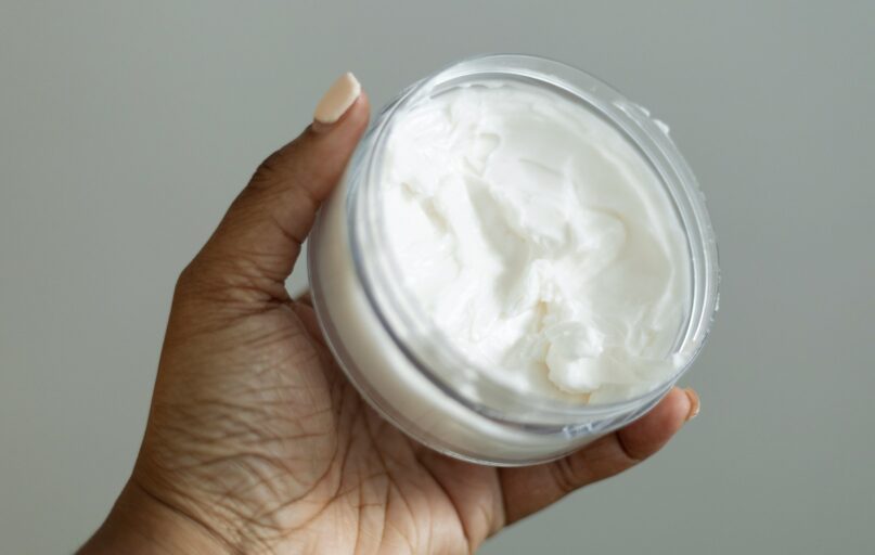 a hand holding a jar of whipped cream