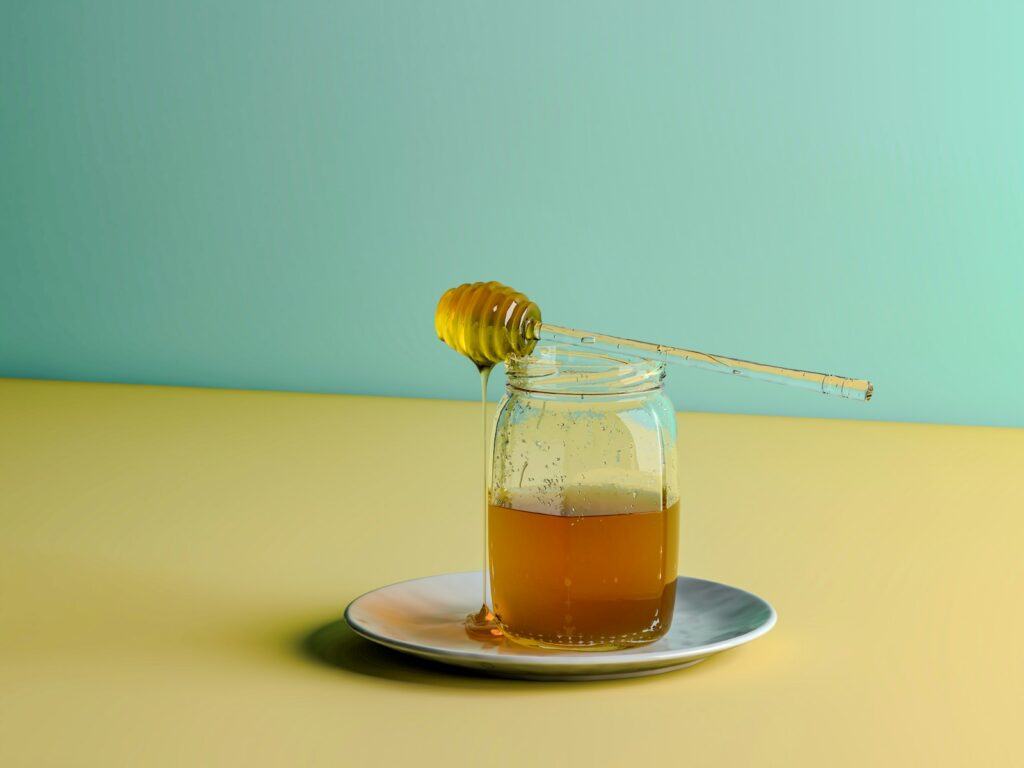a glass jar filled with honey sitting on a plate