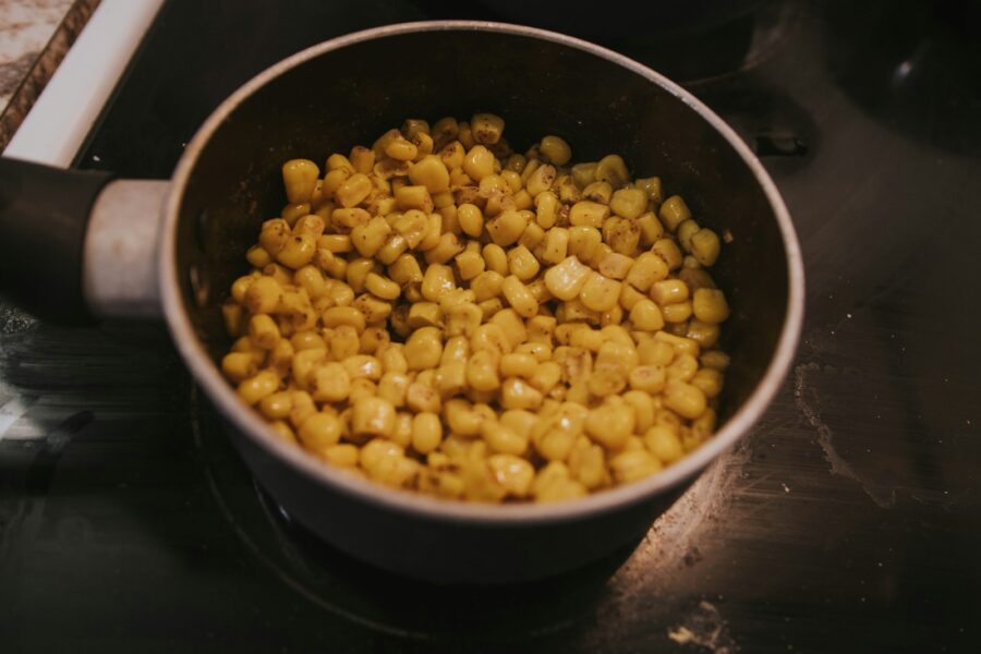 a pot filled with corn sitting on top of a stove