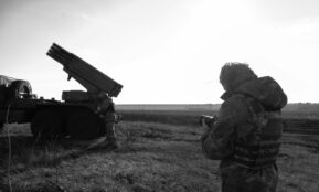 a man standing next to a truck in a field