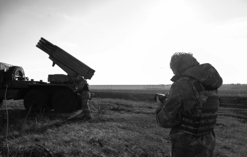 a man standing next to a truck in a field
