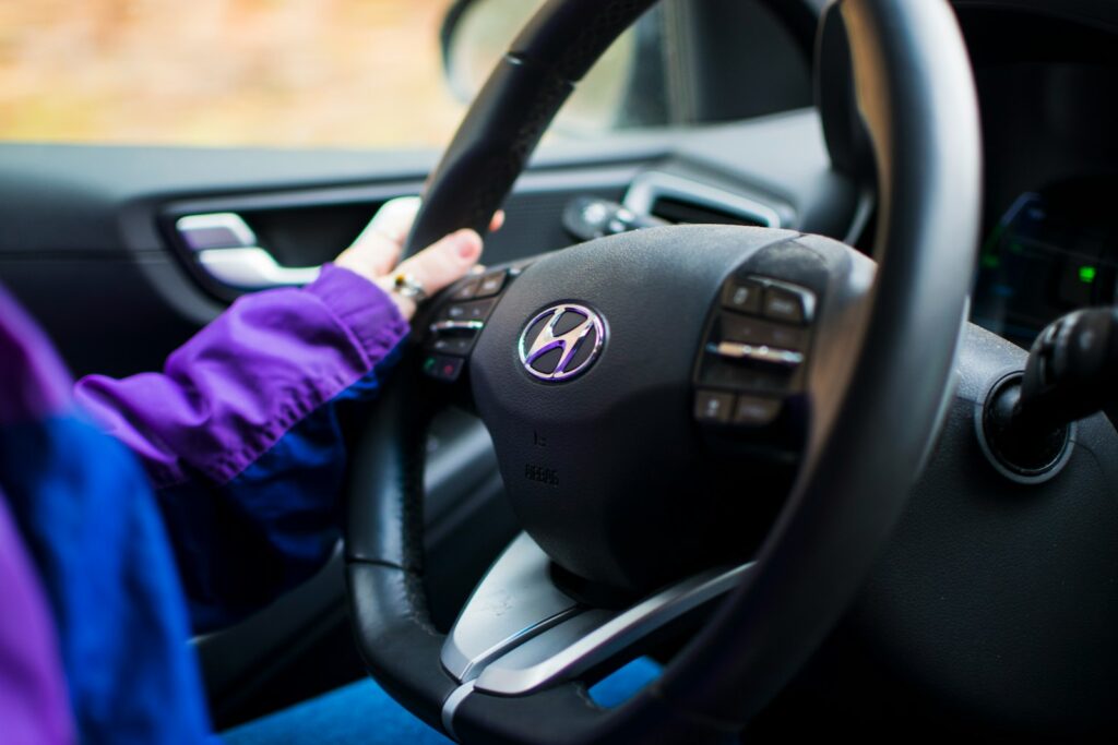 a person driving a car with a steering wheel