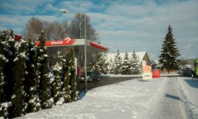 a gas station in the middle of a snowy street