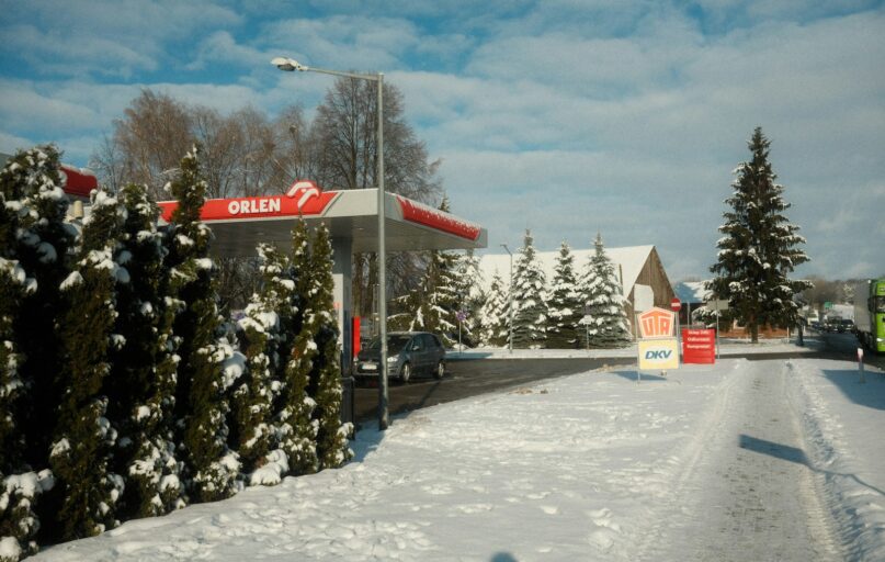 a gas station in the middle of a snowy street