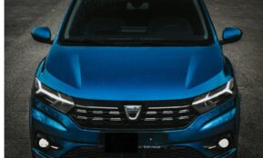 the front of a blue car parked in a parking lot