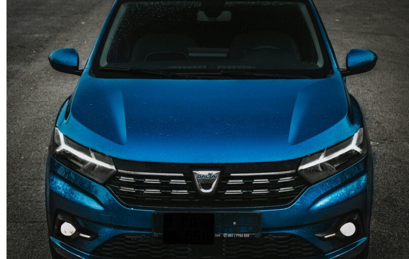 the front of a blue car parked in a parking lot