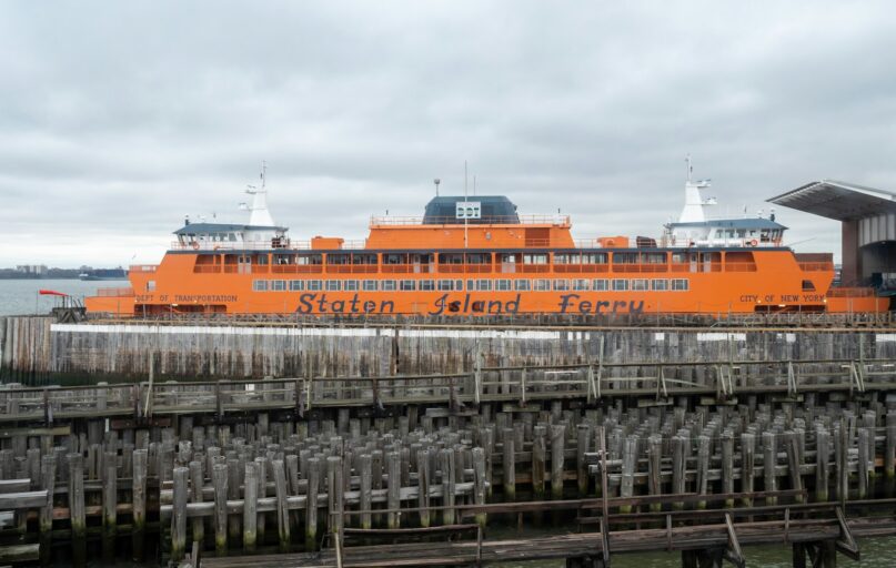 a large orange boat docked at a pier