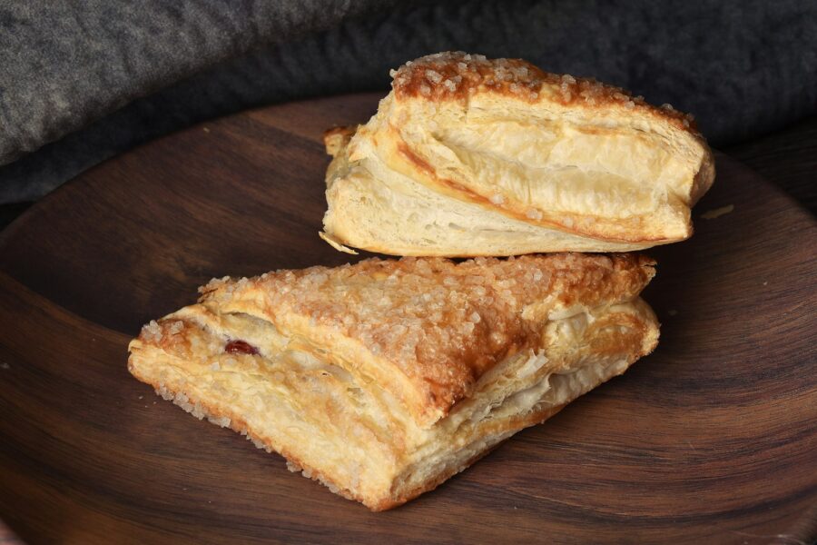 Two pieces of bread sitting on top of a wooden plate