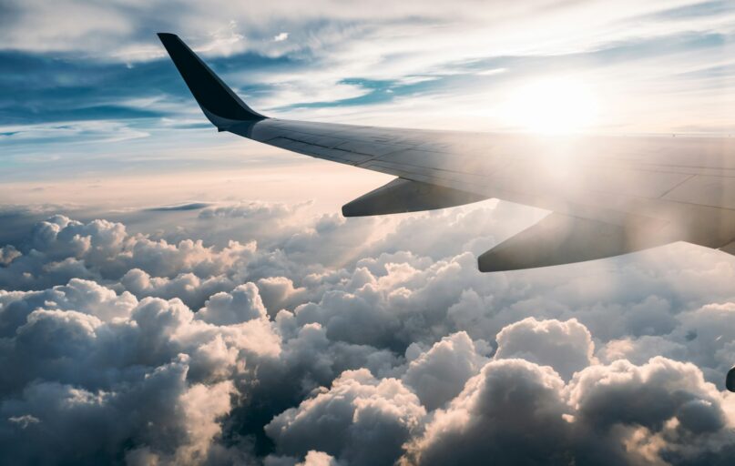 flying airplane over white clouds
