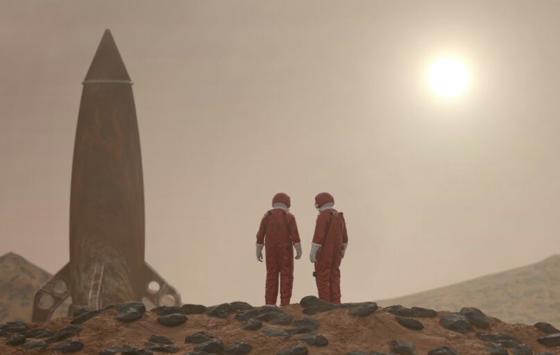 3 men standing on rocky shore during daytime