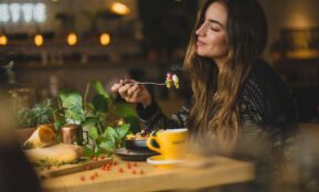 woman holding fork in front table