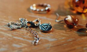 a wooden table topped with lots of different types of jewelry