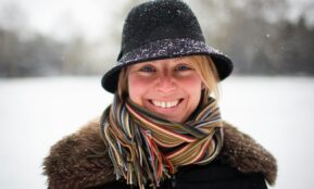 a woman wearing a hat and scarf in the snow