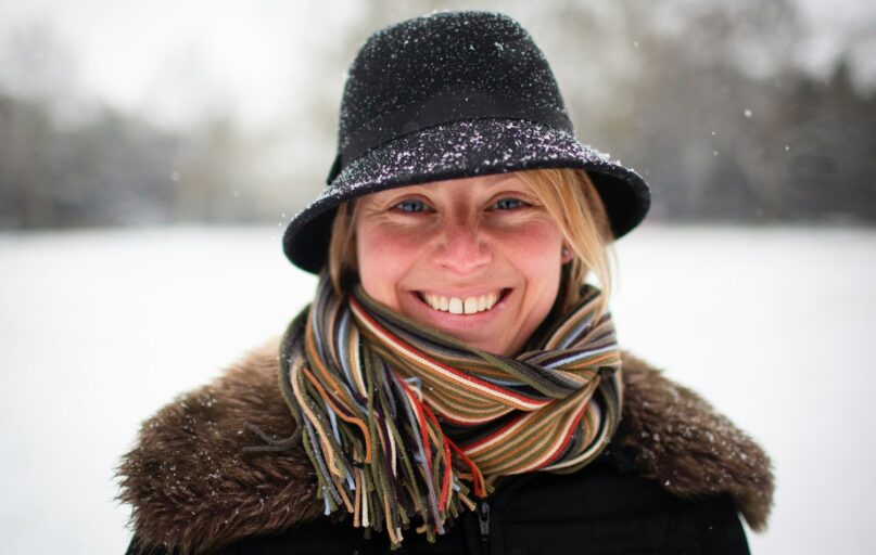 a woman wearing a hat and scarf in the snow