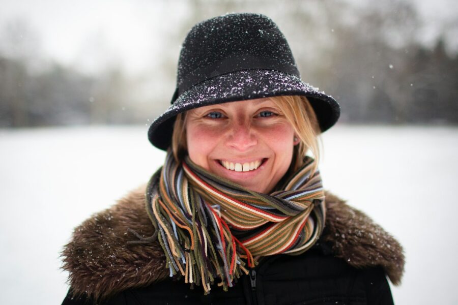 a woman wearing a hat and scarf in the snow