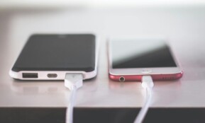 Two smartphones charging side by side on a desk. Modern and technological setting.