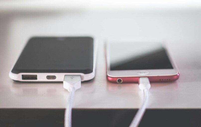 Two smartphones charging side by side on a desk. Modern and technological setting.