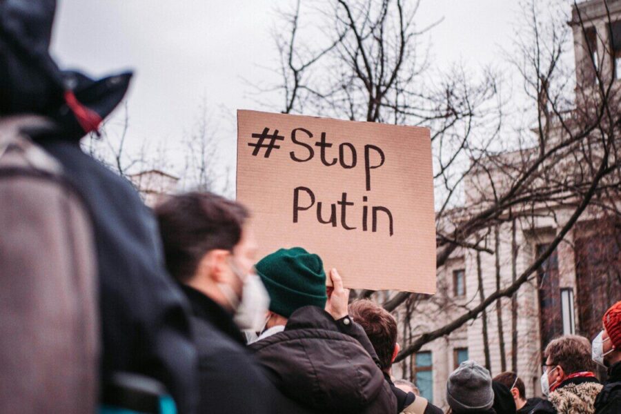 People in Berlin protest against Putin with anti-war signs, showing unity for peace.