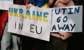 Protest with signs supporting Ukraine in EU and opposing Putin. Capturing a social movement outdoors.