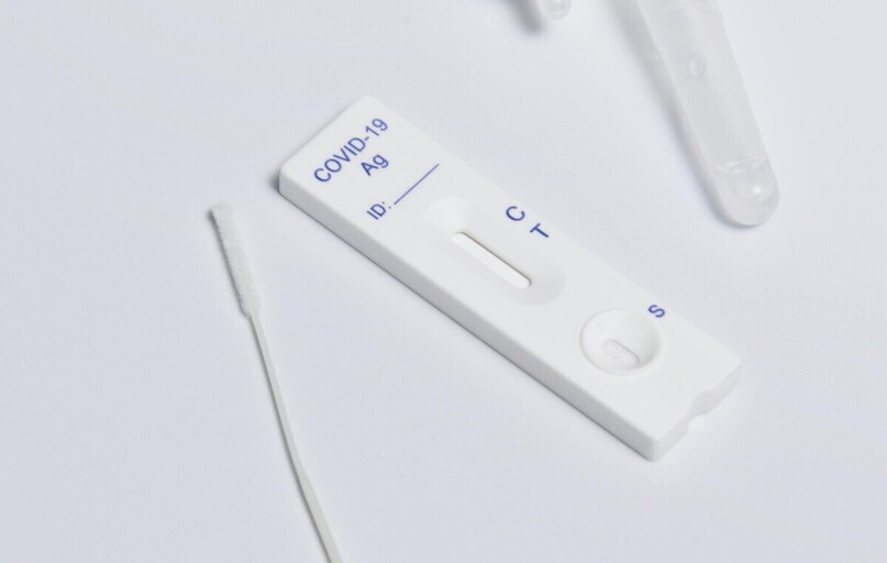 Close-up of a COVID-19 rapid antigen test kit showing the testing strip and swab.