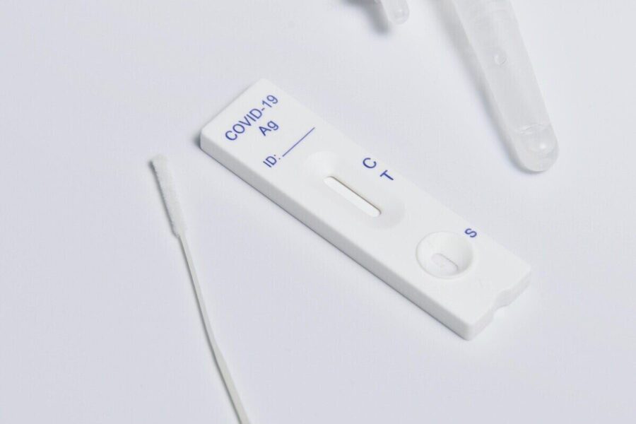 Close-up of a COVID-19 rapid antigen test kit showing the testing strip and swab.