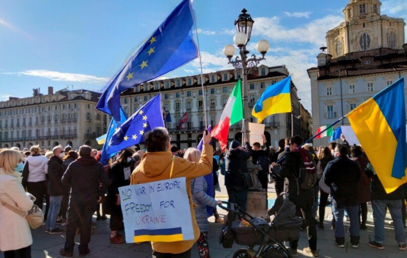 A vibrant protest in Torino advocating for freedom in Ukraine under a clear blue sky.
