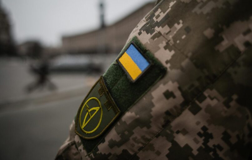 Detailed shot of Ukrainian military uniform with flag patch, symbolizing national pride.