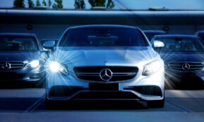 Front view of a lineup of Mercedes-Benz cars with bright headlights, showcasing luxury and elegance.