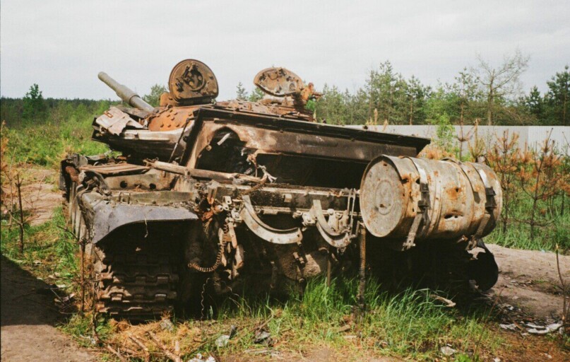 Rusted and damaged tank abandoned in Bucha, Ukraine, symbolizing conflict impact.