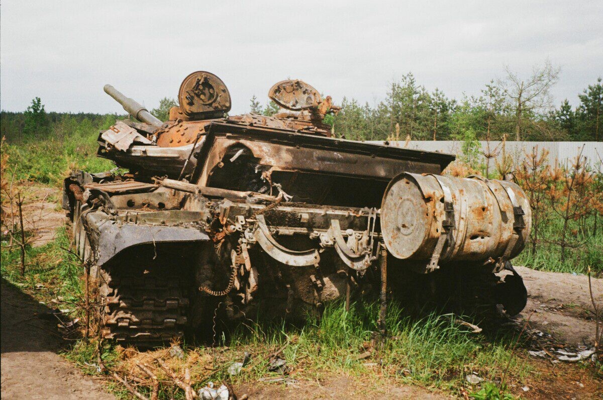 Rusted and damaged tank abandoned in Bucha, Ukraine, symbolizing conflict impact.