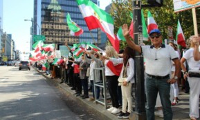 Protesters holding Iranian flags in a peaceful rally on a Vancouver street.