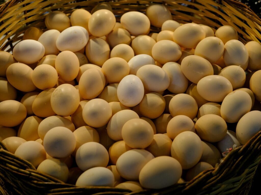Close-up of a basket filled with farm-fresh eggs at a market stall.