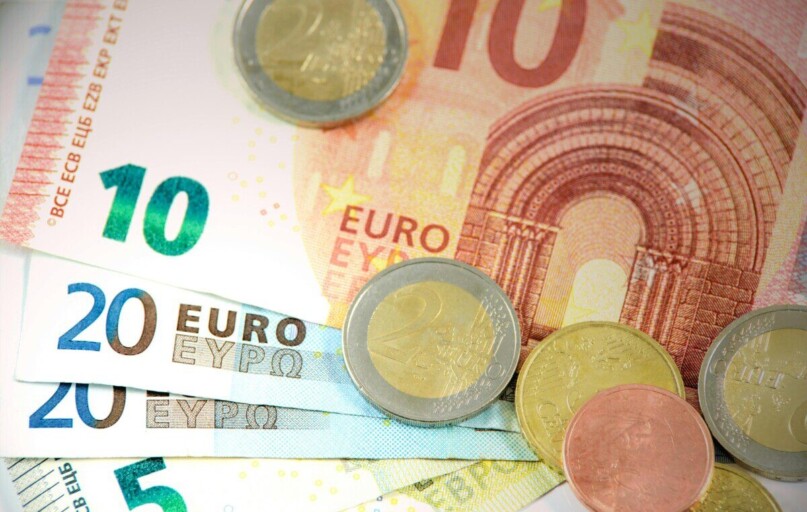 Detailed shot of Euro banknotes and coins showcasing currency denominations.