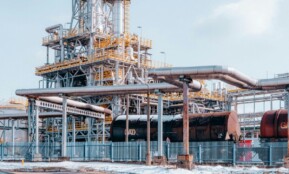 Oil refinery facility with tanker wagons in Trzebinia, Lesser Poland Voivodeship under a clear sky.