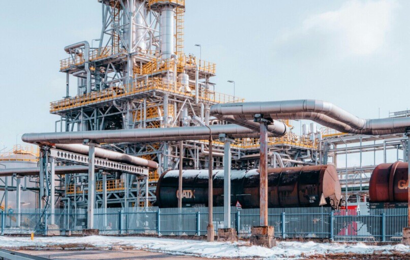 Oil refinery facility with tanker wagons in Trzebinia, Lesser Poland Voivodeship under a clear sky.