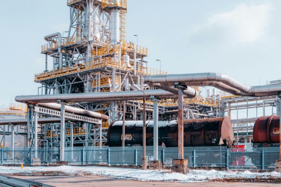 Oil refinery facility with tanker wagons in Trzebinia, Lesser Poland Voivodeship under a clear sky.