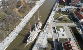 A stunning aerial view of the sailboat Meridian docked in Klaipėda, Lithuania's port.