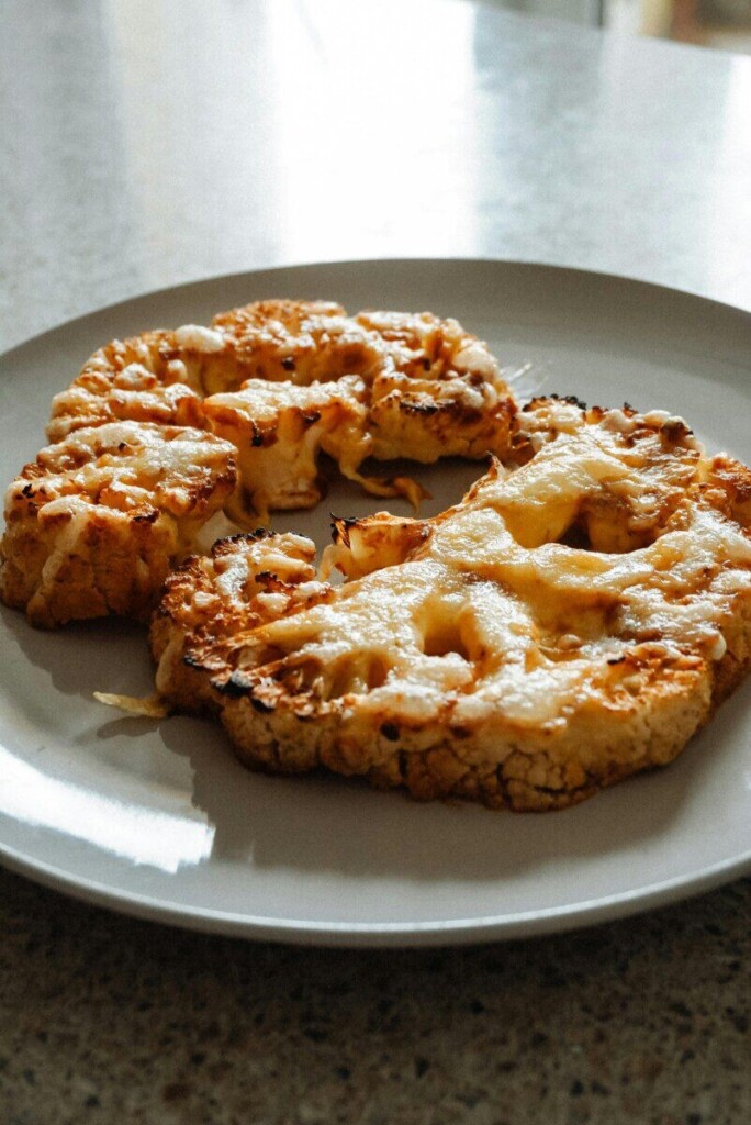 Delicious homemade roasted cauliflower steaks served on a plate, fresh and appetizing.