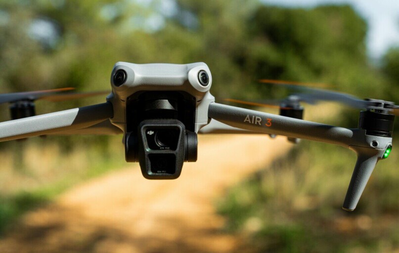 Close-up of DJI Air 3 drone flying over a scenic forest path in Marseille.