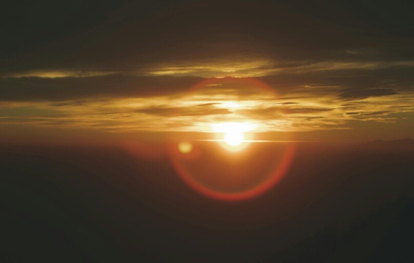 Beautiful sunset with vibrant sun and clouds over Campo dei Fiori, Italy.