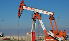 Bati Raman oil pump jack in Batman, Turkey. Industrial landscape with city view.