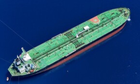 Aerial shot of an oil tanker sailing in the ocean near Vado Ligure, Italy.