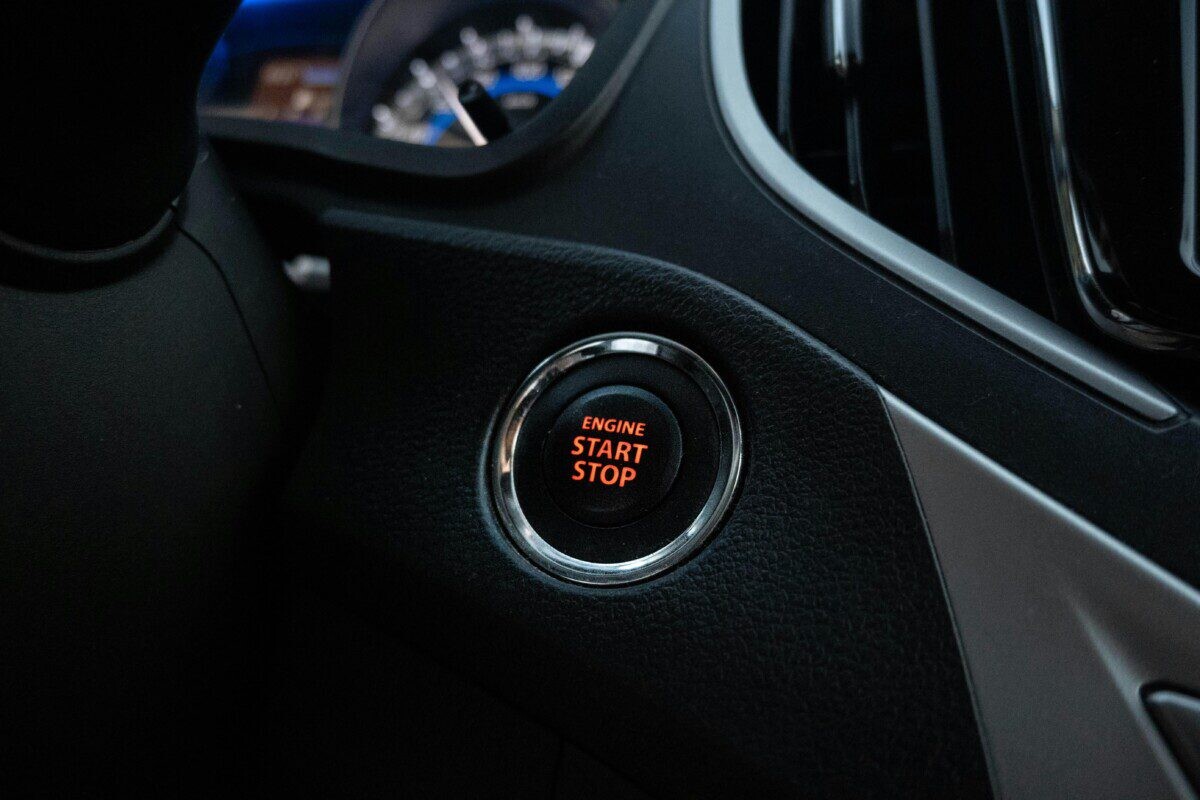 Close-up image of a car's engine start stop button on the dashboard.