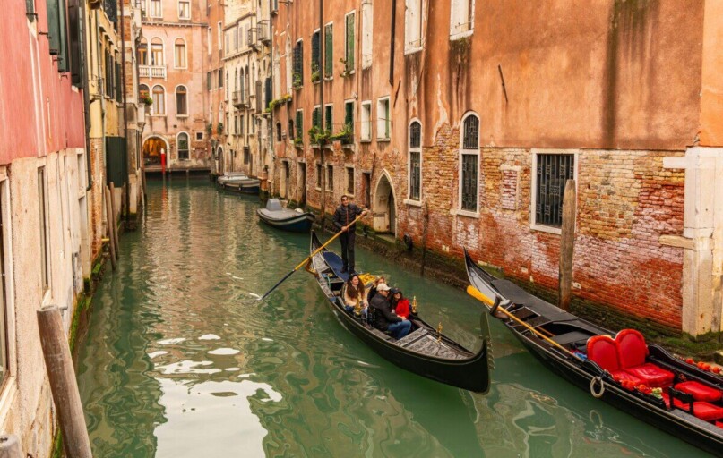 Gondolas on a charming Venetian canal surrounded by historic architecture in Venice, Italy.