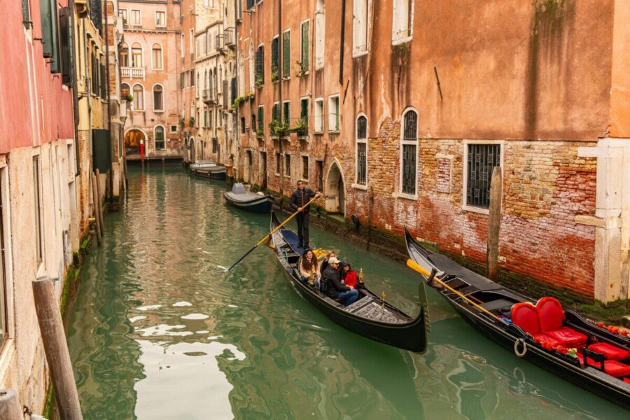 Gondolas on a charming Venetian canal surrounded by historic architecture in Venice, Italy.