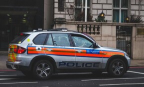 Police vehicle parked on an urban street outside a London building