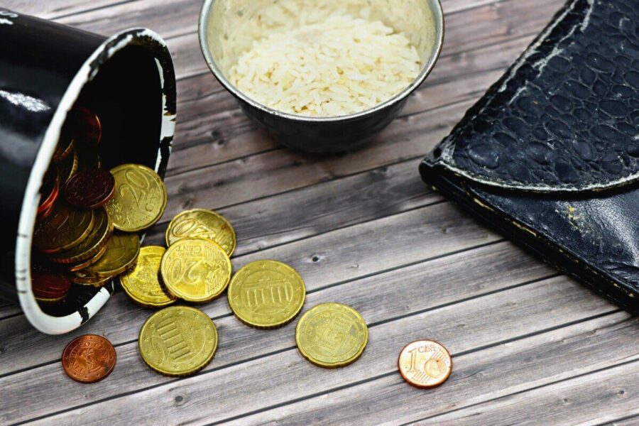 A compelling image capturing coins, a worn-out wallet, and rice, symbolizing economic hardship.